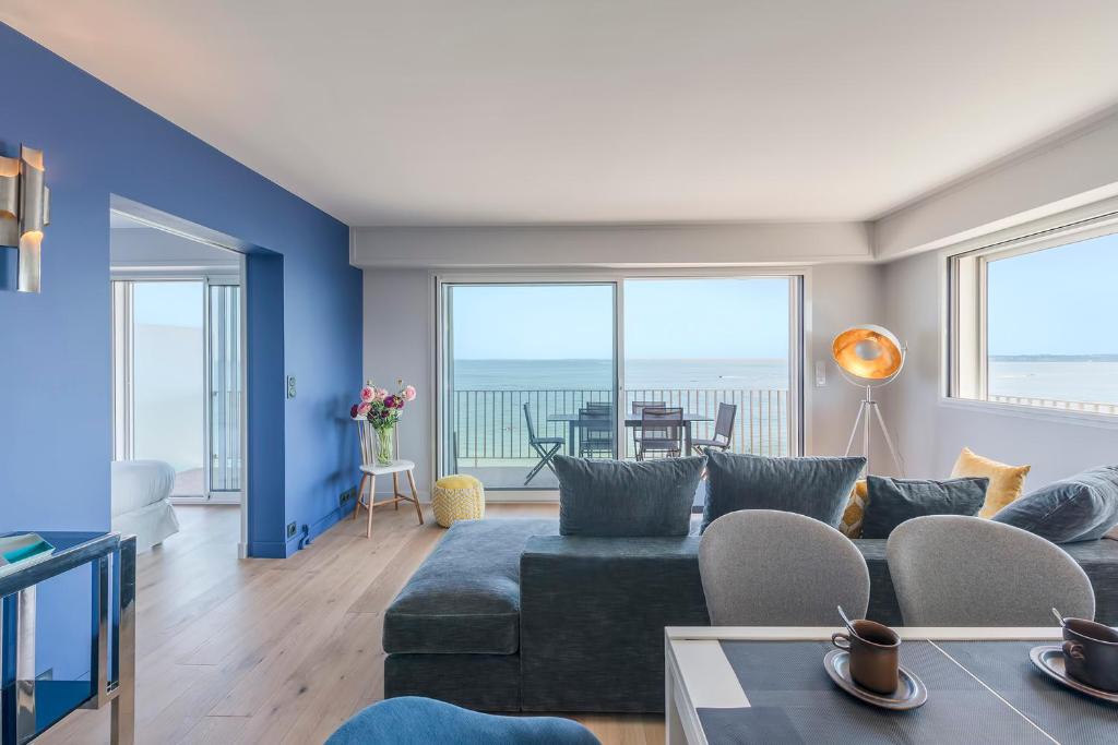 a living room with a couch and a table at Vue sur mer La Baule Victoria in La Baule