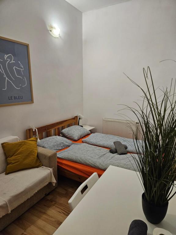 two beds in a room with a couch and a table at Vibrant City Center Rooms in Budapest