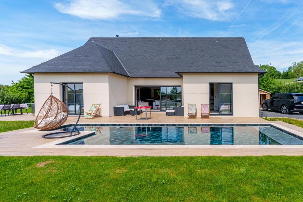 une maison avec une piscine devant dans l'établissement Villa chic à 5 minutes de Deauville, à Canapville