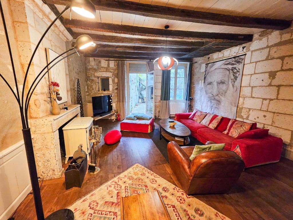 - un salon avec un canapé rouge et un mur en briques dans l'établissement Maison 8 pers en plein coeur d'Angoulême, à Angoulême