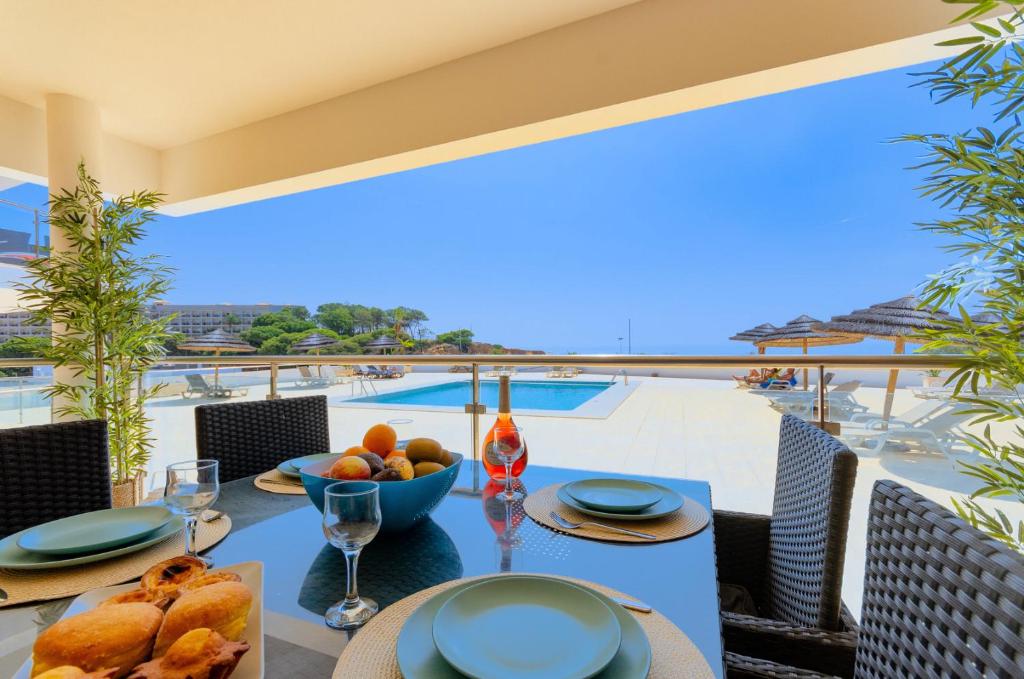 a table with a bowl of fruit on a balcony at Varandas do Mar, Olhos de Agua, 1 Bed Apt AT23 in Olhos de Água