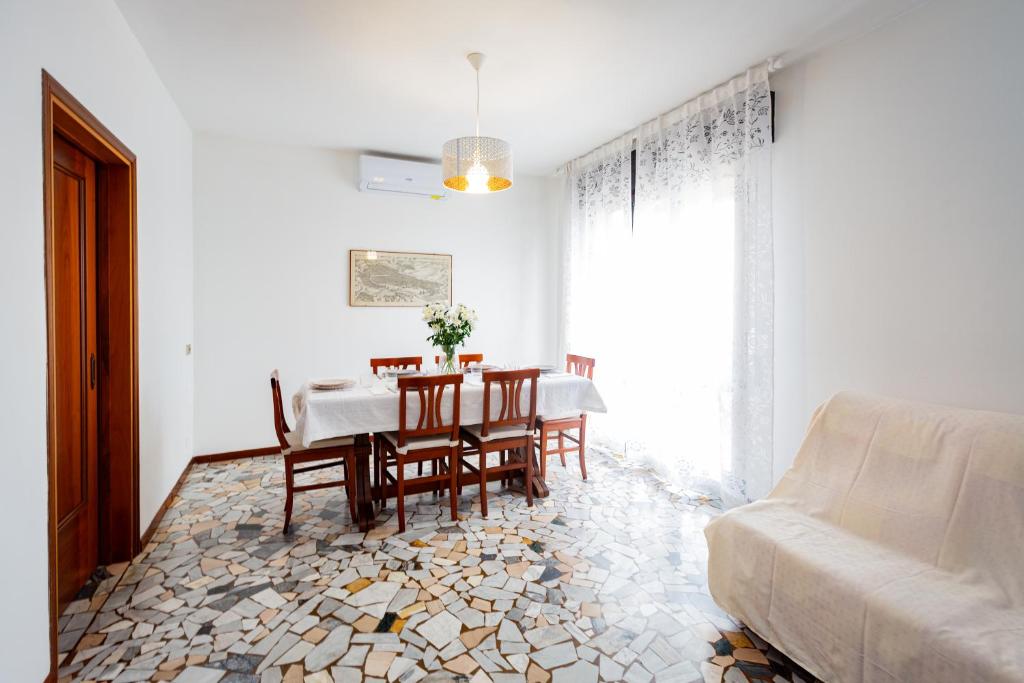a dining room with a table and chairs and a couch at Liviana Apartment Venice- Spacious,Free Parking,Easy Access to Venice in Marghera