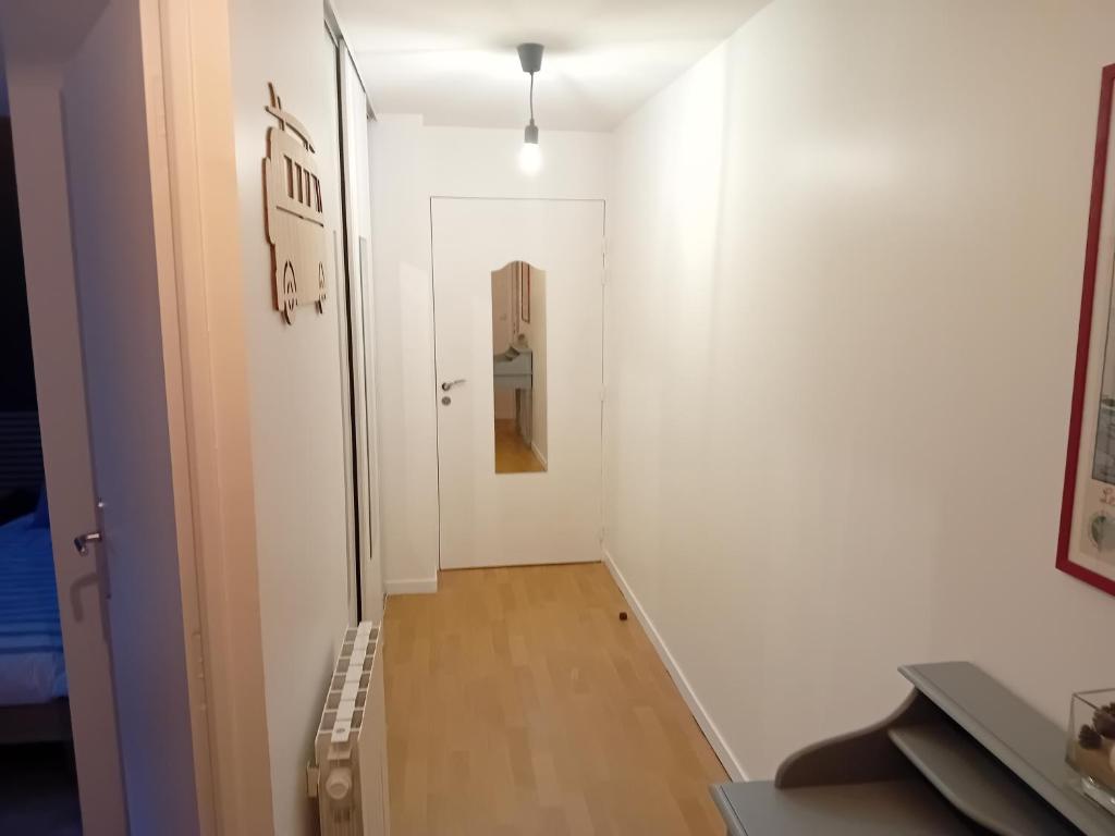 un couloir avec un mur blanc et une porte blanche dans l'établissement agathe&compagnie, à La Celle-sous-Gouzon