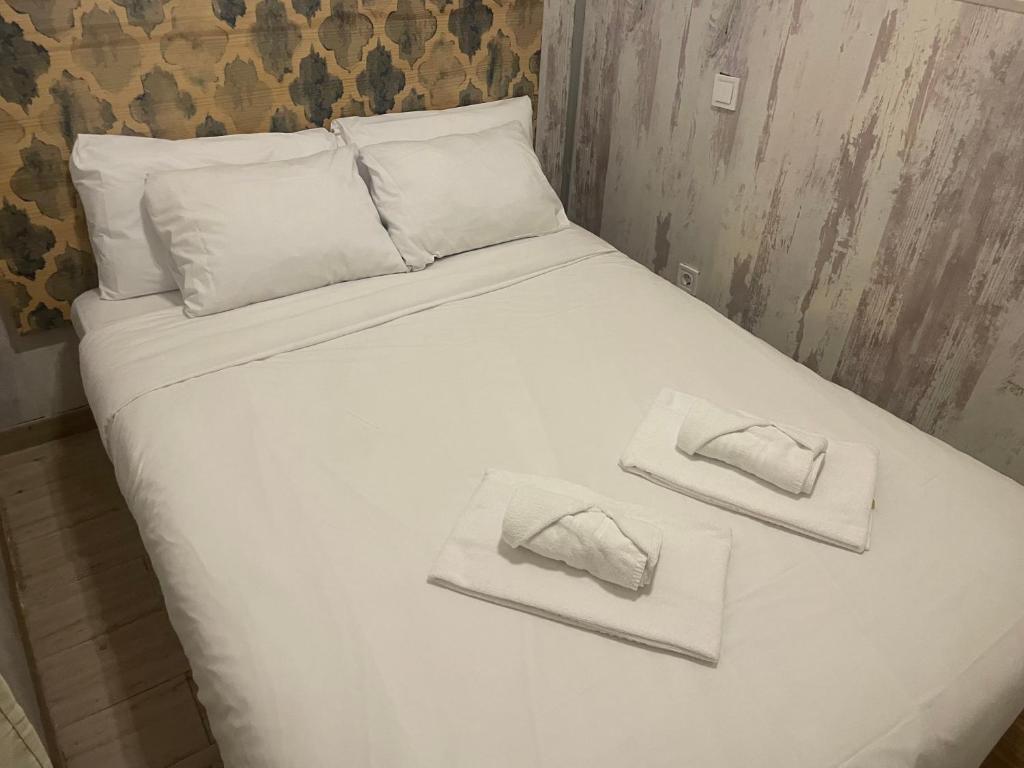 a white bed with two folded towels on it at Sebastian Elcano, Metro Embajadores, centro de Madrid in Madrid