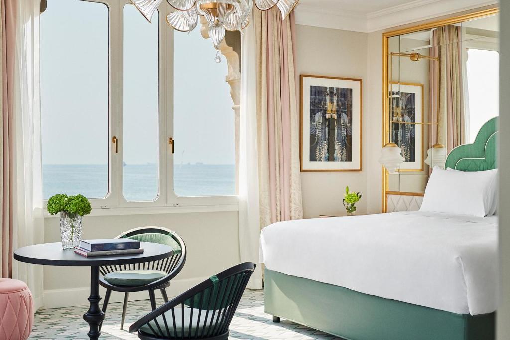 a bedroom with a bed and a table and chairs at Hotel Excelsior Venice in Venice-Lido