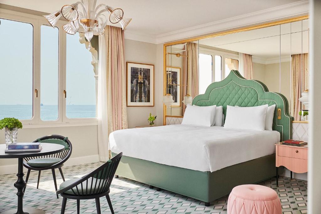 a bedroom with a large bed and a table and chairs at Hotel Excelsior Venice in Venice-Lido