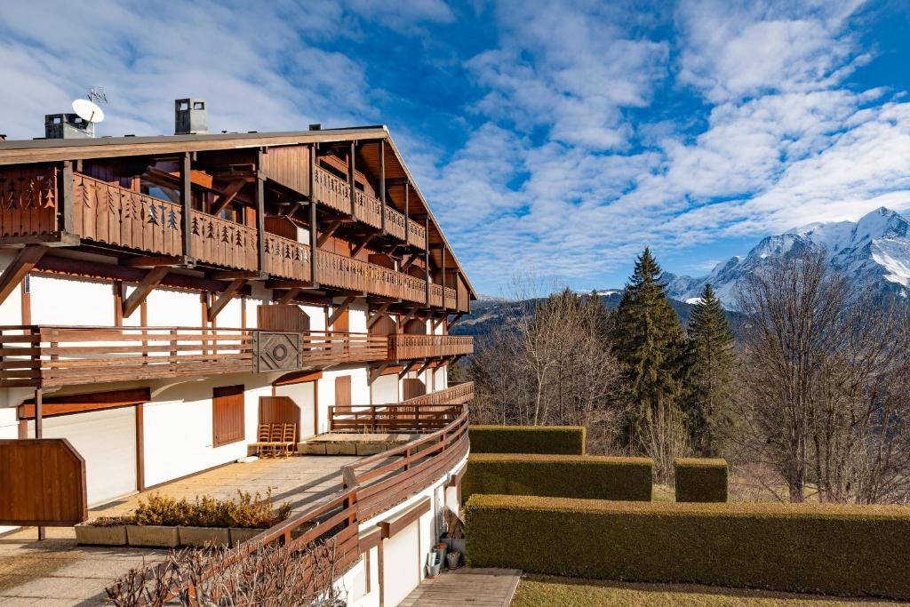 a building with a balcony with mountains in the background at Studio Cabine Saint-Gervais in Saint-Gervais-les-Bains