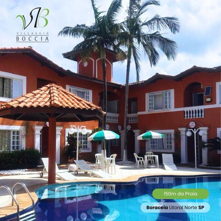 a resort with a swimming pool and palm trees at Villaggio Boccia in Bertioga