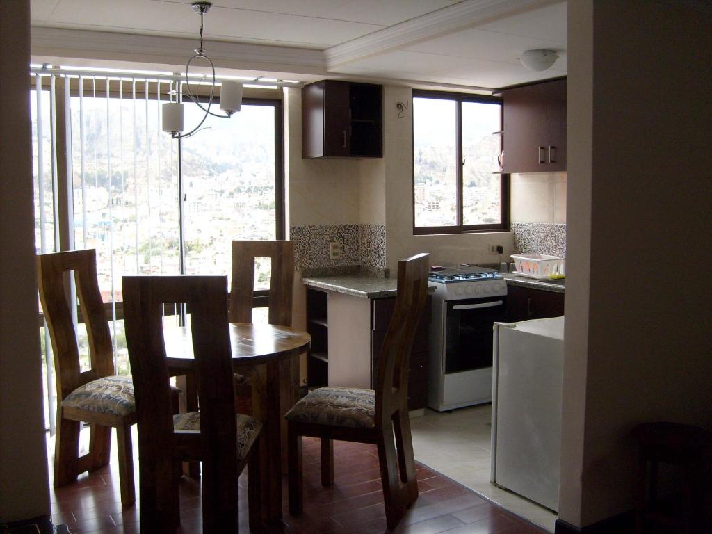 cocina con mesa y sillas y cocina con ventana en A Place in the Sky - c23 Calacoto, en La Paz