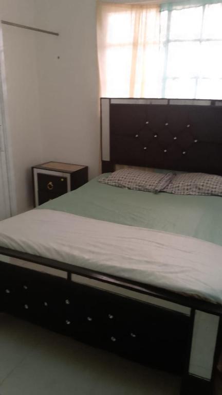 a bed in a bedroom with a bed frame and a window at Queen Bmazazhi Stay in San Pedro de Macorís