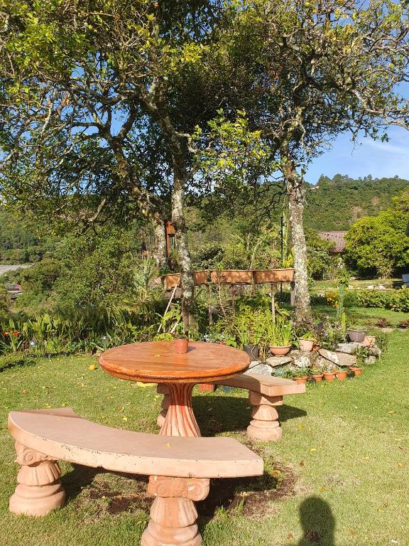 a picnic table and two benches in a park at Hostal Vista Boquete in Bajo Boquete