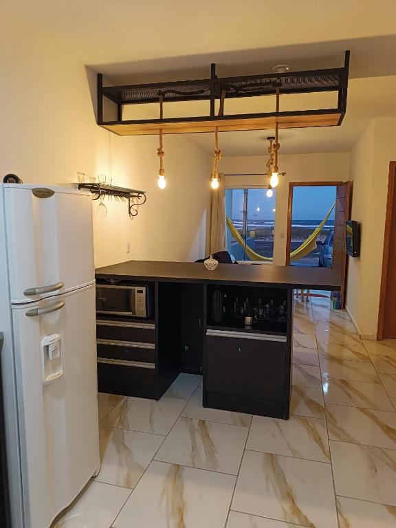 a kitchen with a refrigerator and a counter top at Relaxe à Beira-Mar com pé na areia! in Tramandaí