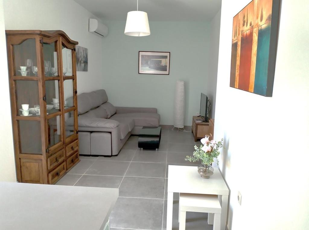 a living room with a couch and a table at Ático Sol & Mar - La Línea in La Línea de la Concepción