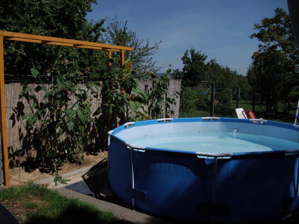 a blue hot tub in a yard next to a fence at Ferienhaus Hartmann in Hévíz