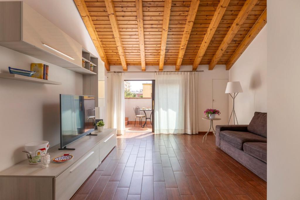 ein Wohnzimmer mit einem TV und einem Sofa in der Unterkunft SAVOIA 173 - Apartment in Acireale