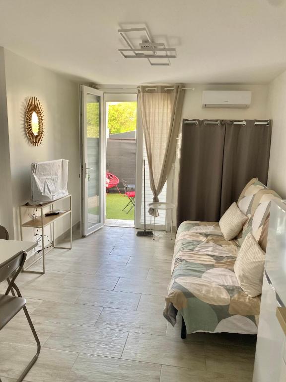 une chambre avec un lit et une porte coulissante en verre dans l'établissement Escapade ensoleillée Studio, à La Seyne-sur-Mer