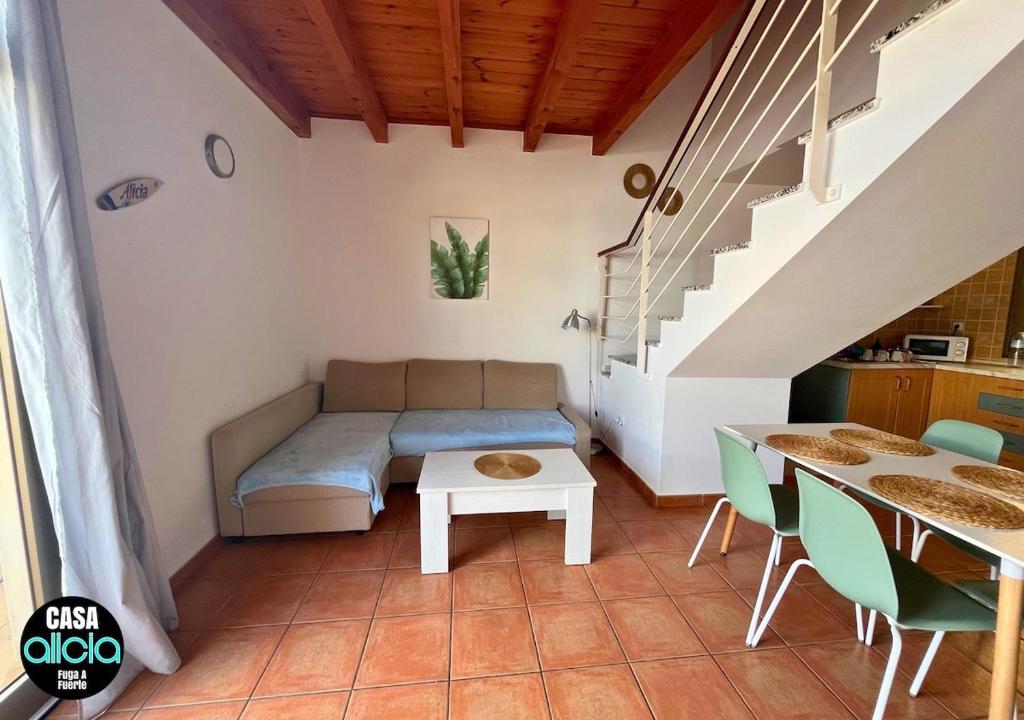 a room with a bed and a table and stairs at Casa Alicia - El Cotillo - 2 Camere, 2 Bagni in El Cotillo