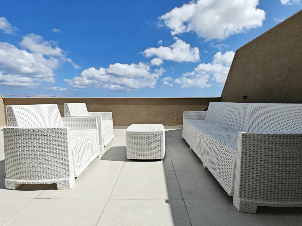 a row of white chairs sitting on a roof at SkyHaus in Fgura