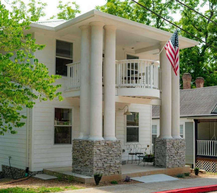 a house with columns and an american flag at -NEW- Spring Wish - Historical Loop Home- in Eureka Springs