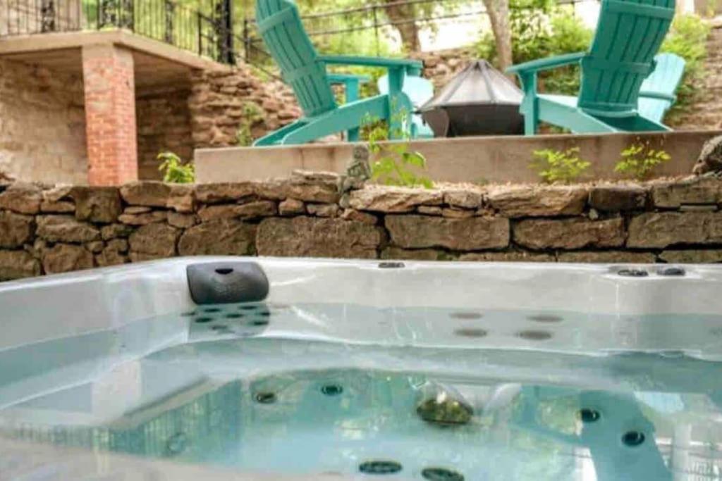 a jacuzzi tub in a yard with a bench and chairs at 151 Spring Downtown Eureka Springs Suite A in Eureka Springs