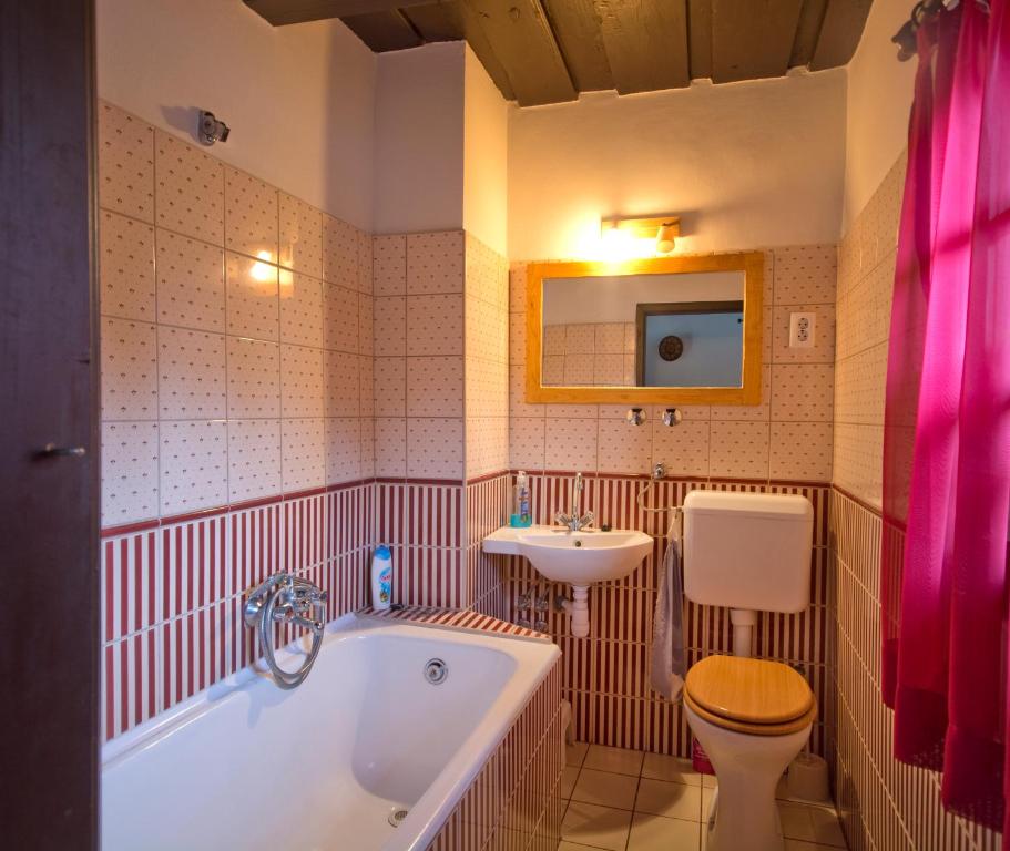 a bathroom with a tub and a toilet and a sink at Csörgő Vendégházak in Szalafő