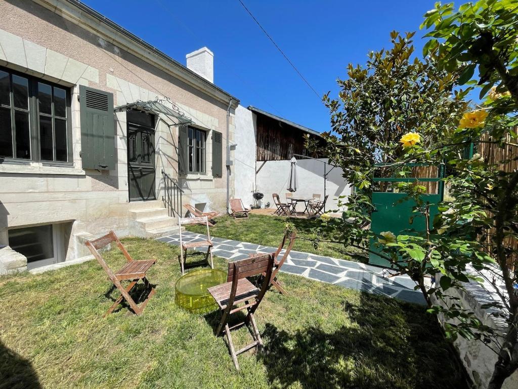 une cour avec des chaises et une table ainsi qu'un bâtiment dans l'établissement Charmante maison jardin centre, à Chinon