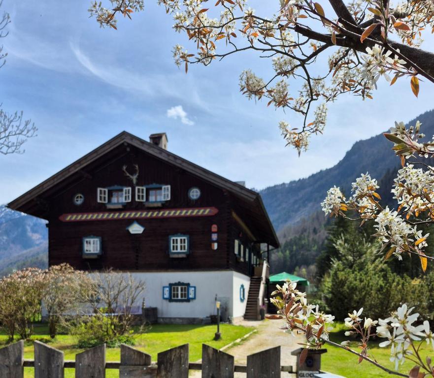 duży brązowy i biały dom z górami w tle w obiekcie Ferienlounge Bluntausee w mieście Golling an der Salzach
