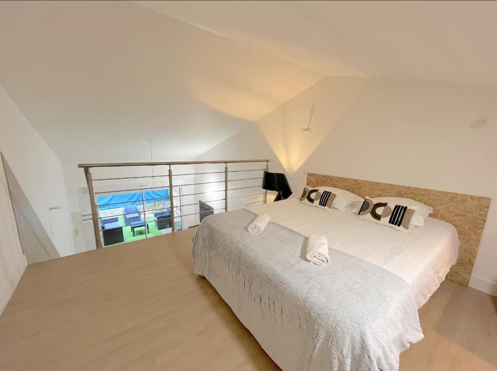 une chambre blanche avec deux lits et une fenêtre dans l'établissement Duplex Tanay, à Annecy