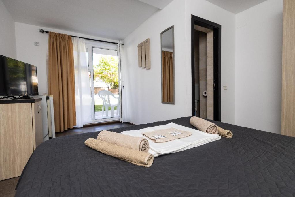 a bedroom with a large bed with towels on it at Vila Cornelius in Costinesti
