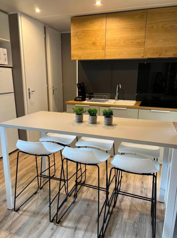 une cuisine avec une grande table blanche et des tabourets dans l'établissement Zen, à Saint-Cyprien