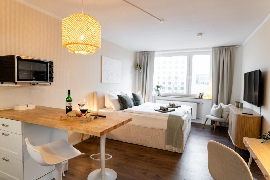 a hotel room with a bed and a table with wine glasses at Zentral Fußgängerzone für Paare und Geschäftsreisende, Kinderfreundlich in Wolfsburg