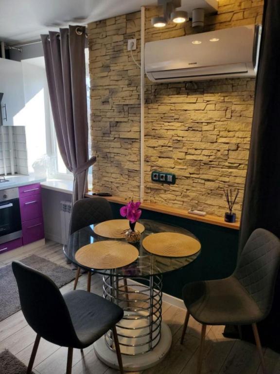 a dining room with two tables and chairs and a brick wall at Stone city center ІІ in Kamianets-Podilskyi