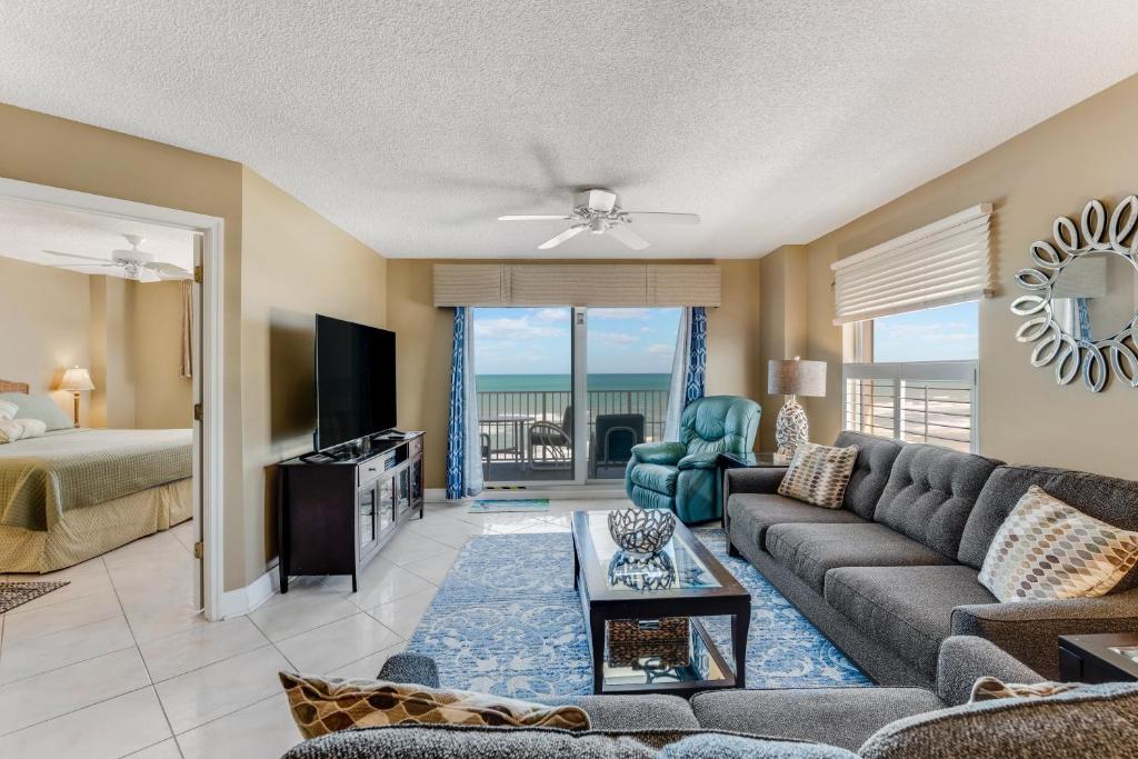 un salon avec un canapé et un lit dans l'établissement Direct oceanfront corner condo with spacious balcony and heated beachfront pool, à Ormond Beach