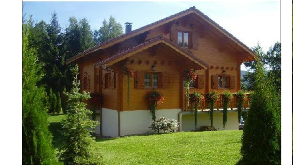 a house with flowers in front of it at gîte avec spa, sauna et piscine in Le Thillot