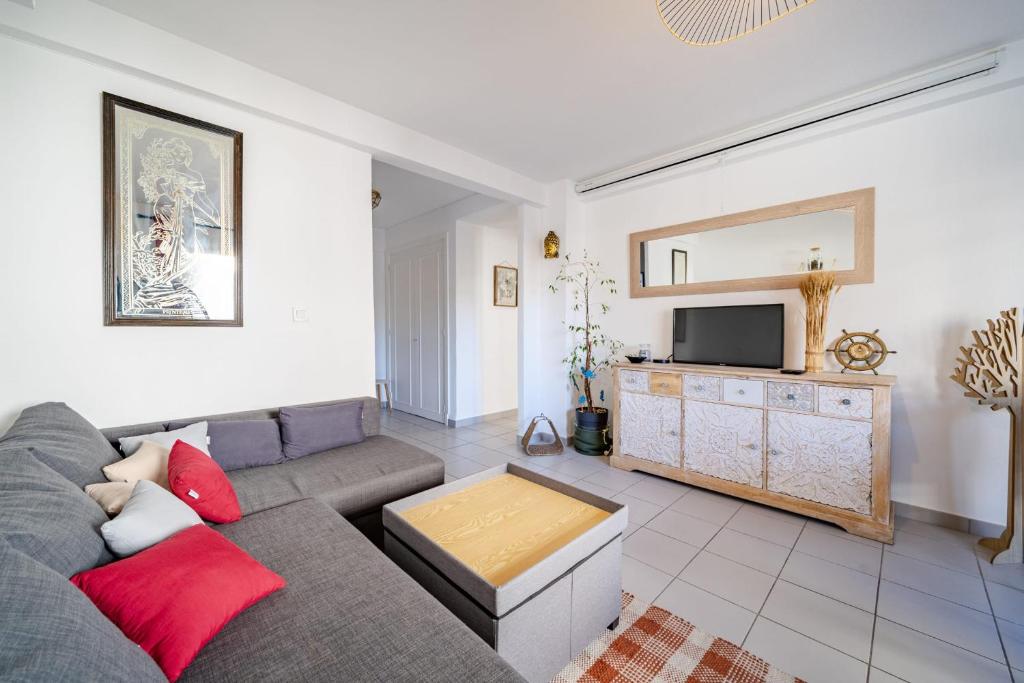 un salon avec un canapé et une télévision dans l'établissement Appartement Rochat - Welkeys, à Antibes