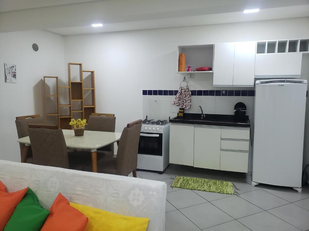 a kitchen with white cabinets and a table with chairs at Ap super espaço próximo a 25 de março in Sao Paulo