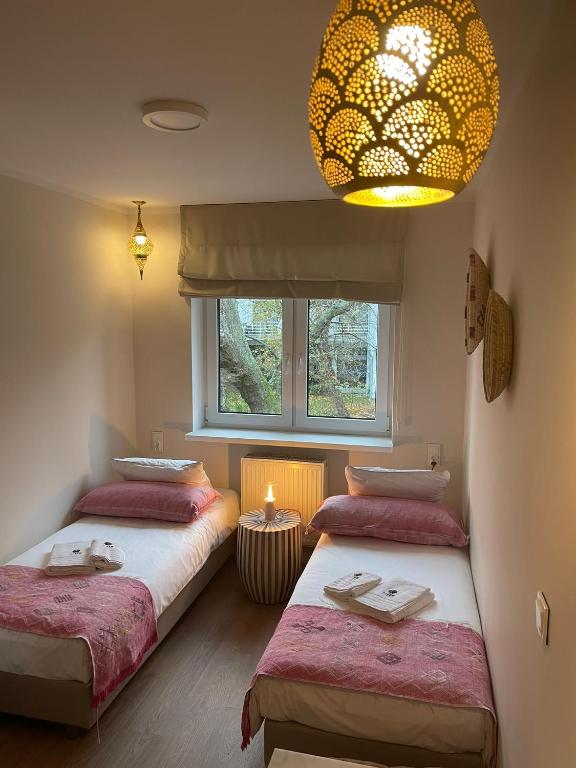 a bedroom with two beds and a chandelier at Villa boZEN w Juracie in Jurata
