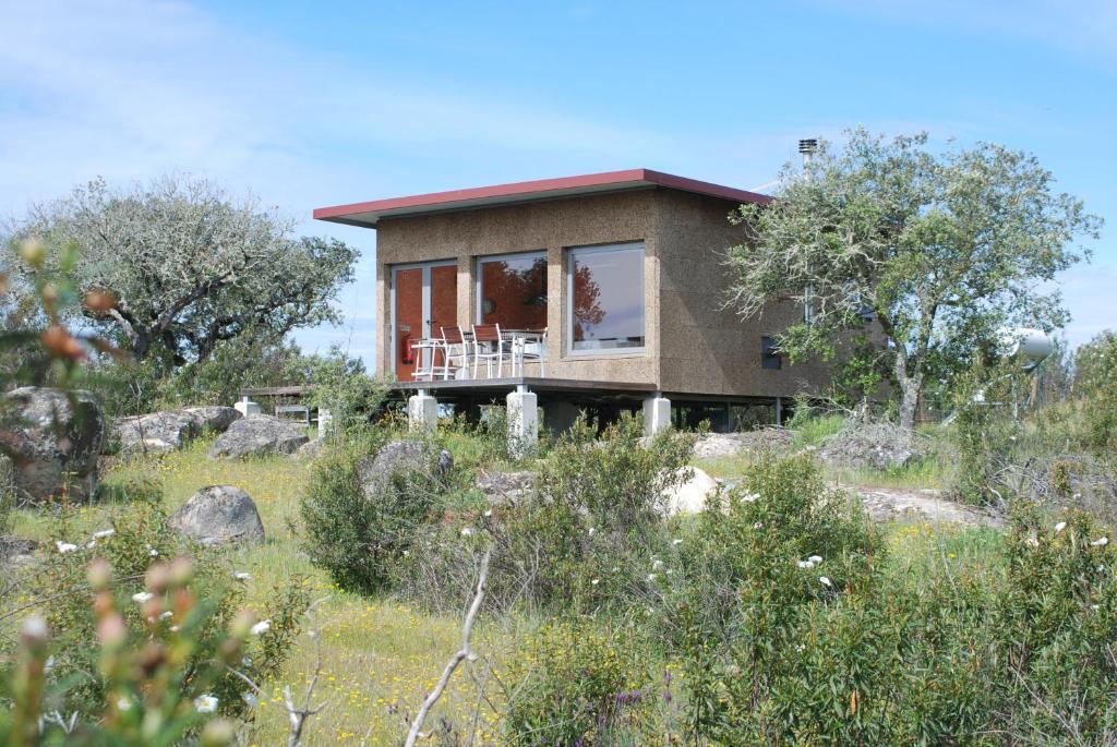 a house on top of a hill with trees at Bubulcus and Bolotas - Off Grid Nature Holiday Home in Vimieiro