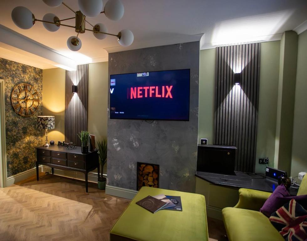 a living room with a netflix sign on a wall at NEW Refurbished 2025 Cottage Sleeps 6 Ashbourne Peak District Derbyshire in Ashbourne