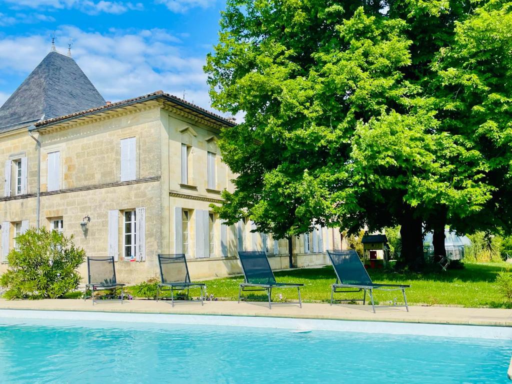a group of chairs sitting in front of a house at Gîte & Spa Château Lagrange les Tours in Cubzac-les-Ponts