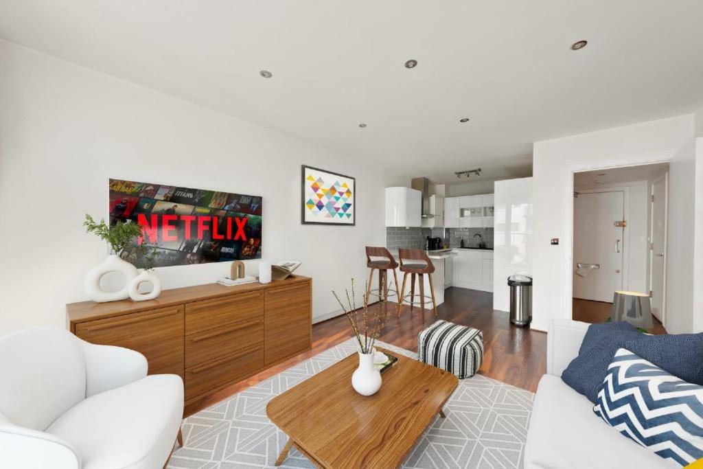 a living room with a couch and a table at SG, Charming Chelsea Balcony Suite in London