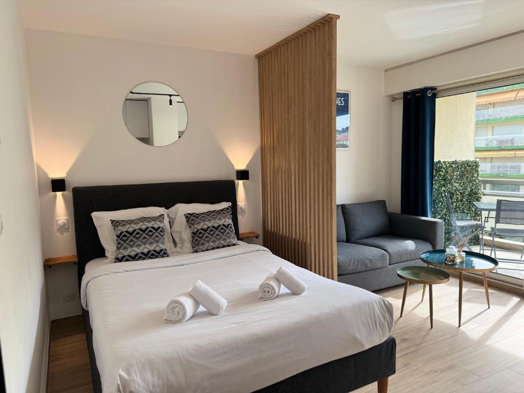 une chambre avec un grand lit et un canapé dans l'établissement Cosy Appartement, Centre-ville Cannes, Terrasse, Clim, à Cannes