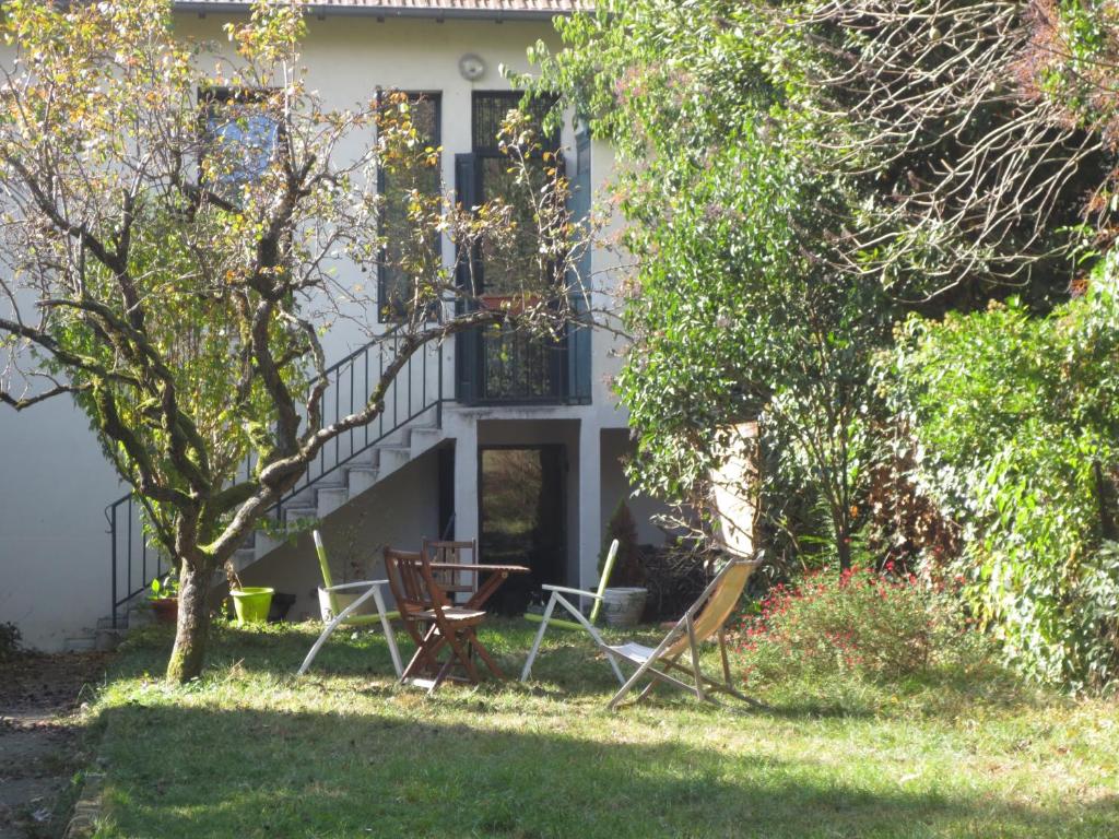 une maison avec deux chaises et une table dans la cour dans l'établissement VILLA GUILHEMERY LES ANNÉES 30 - Le jardin enchanté, à Toulouse