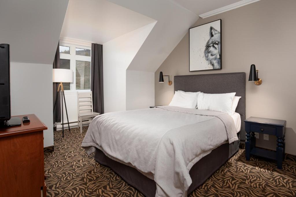 a hotel room with a bed and a television at Sommet Des Neiges in Mont-Tremblant