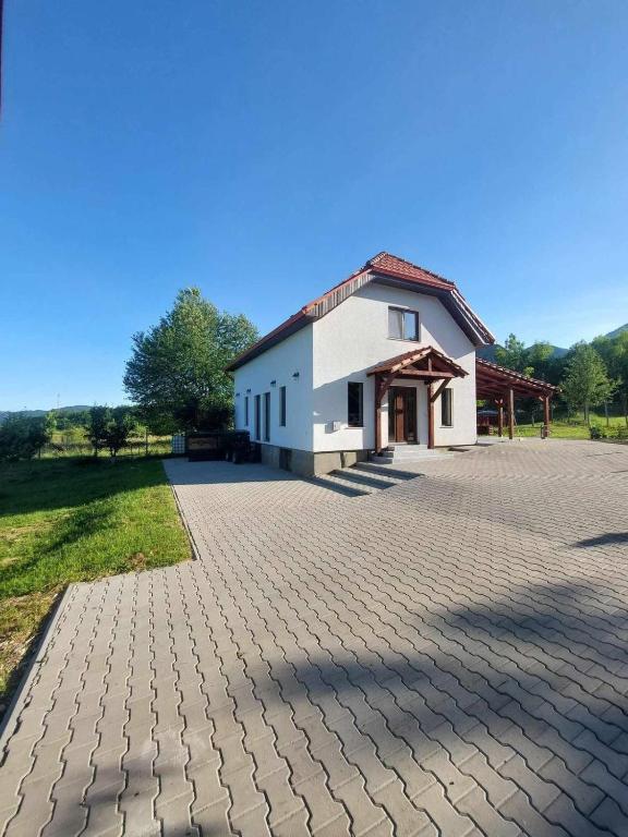a building with a brick driveway in front of it at Cabana Gap House in Colţeşti