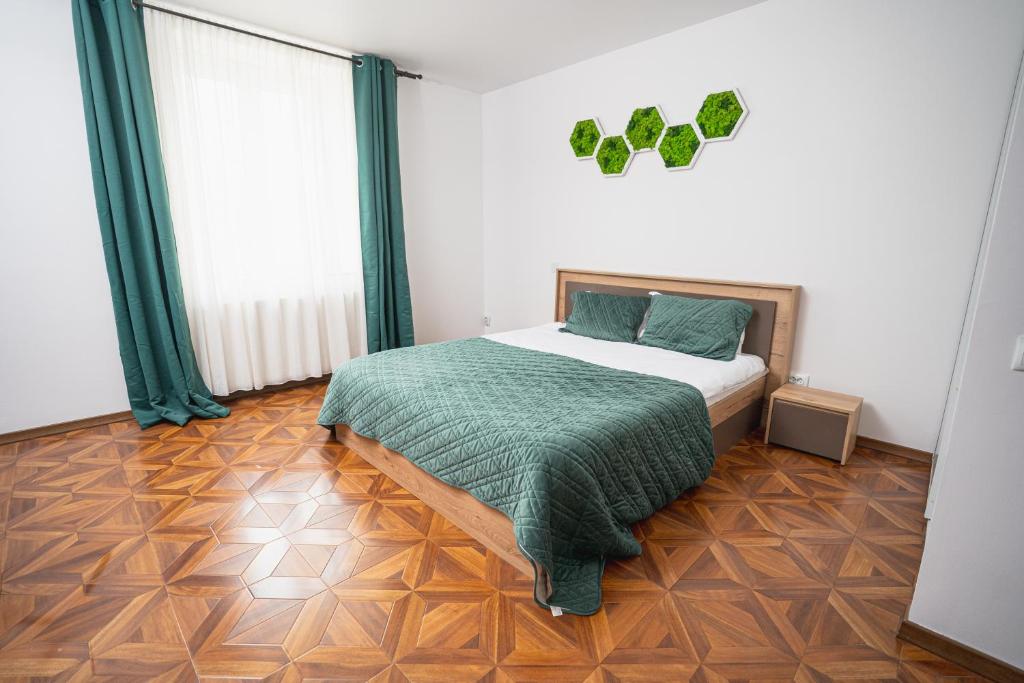 Un dormitorio con una cama con una manta verde encima. en MB Studio, en Brasov