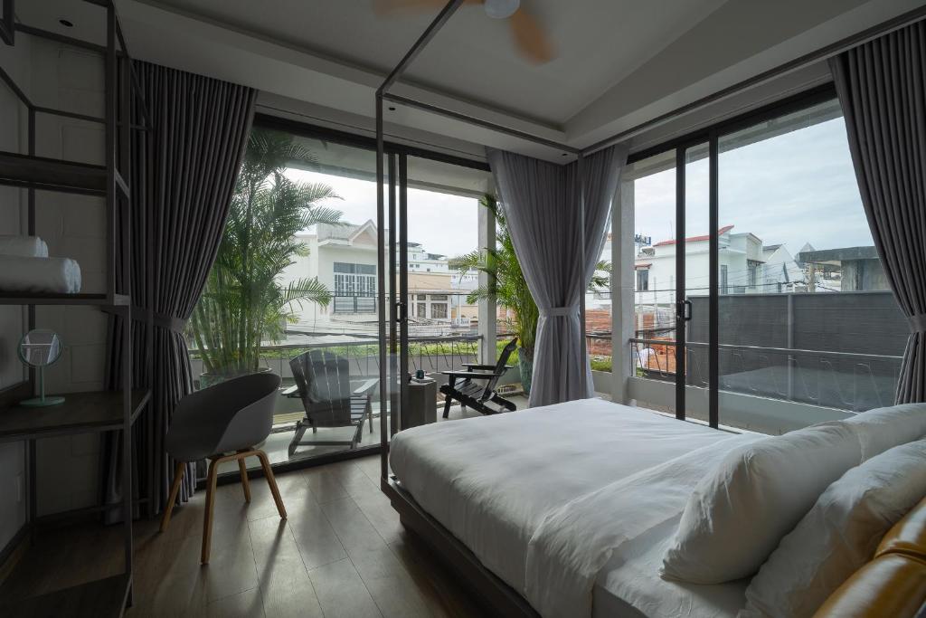 a bedroom with a bed and a large window at K House Phan Thiet by Blue Fingers in Ấp Bình Hưng