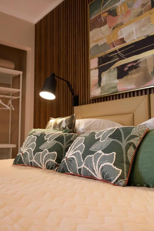 a bedroom with a bed with a blanket and a lamp at Dabney3 Apartments in Madalena
