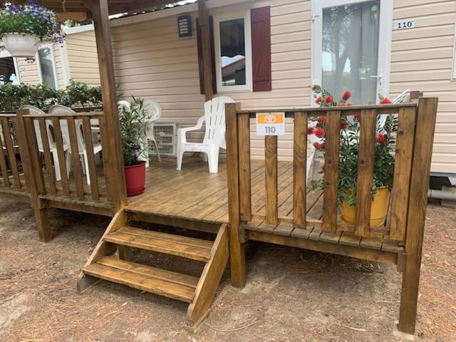 une terrasse en bois devant une maison dans l'établissement mobil home la palmeraie, à Torreilles