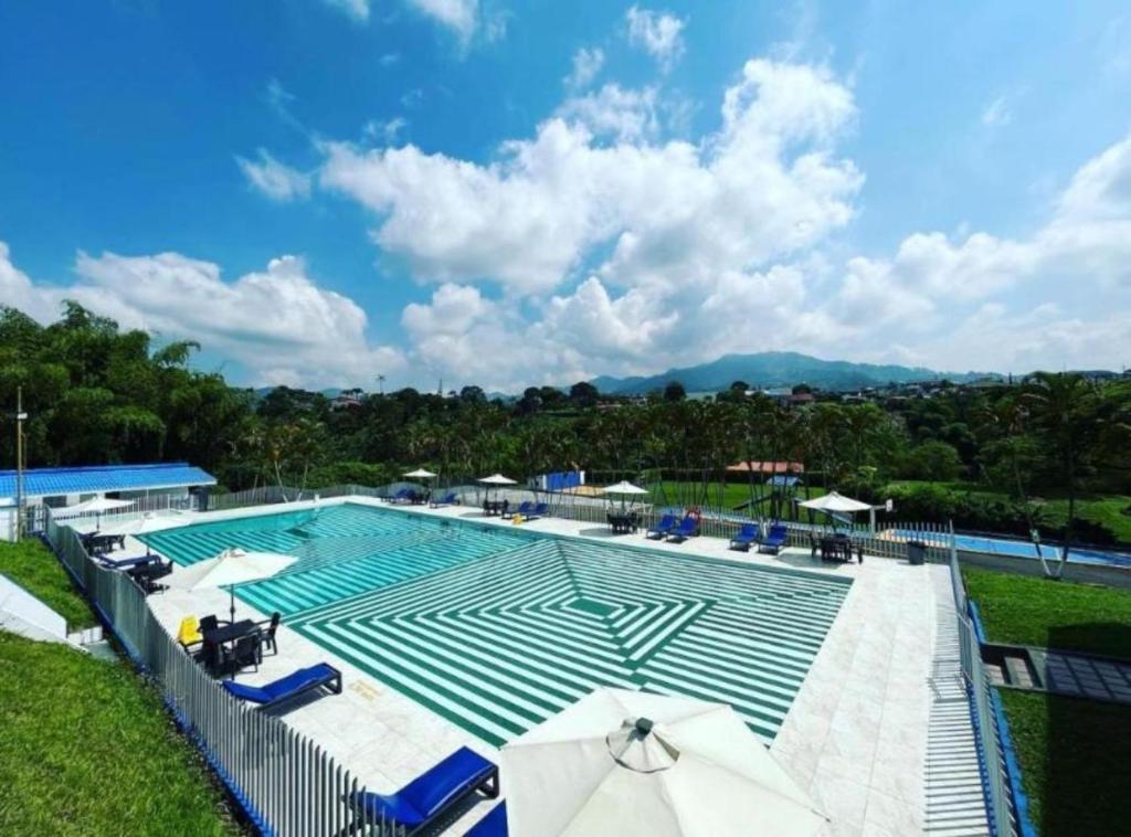 una gran piscina con sillas y sombrillas en Hotel Villa Mónaco, en Pereira